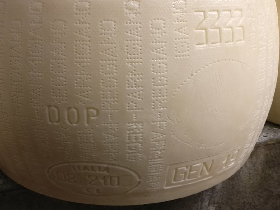 Parmigiano Reggiano guide - a wheel marked DOP by the Consortium